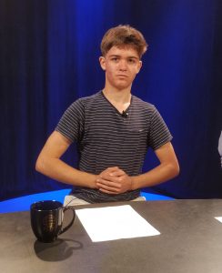 Me crossing my arms at an anchor desk