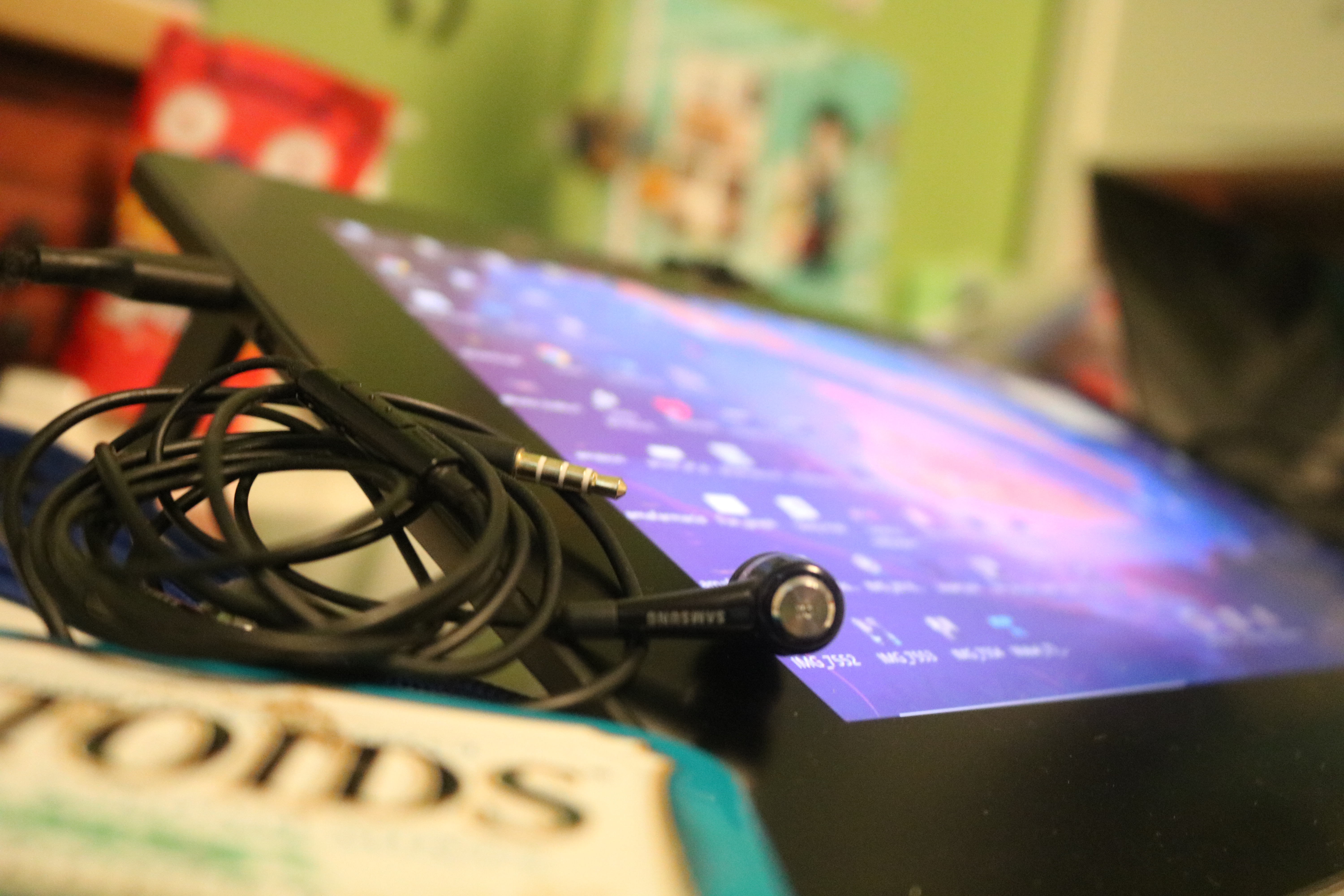 This photo describes all of my passions, and showcases a tin of Altoids, earbuds, and a drawing tablet.