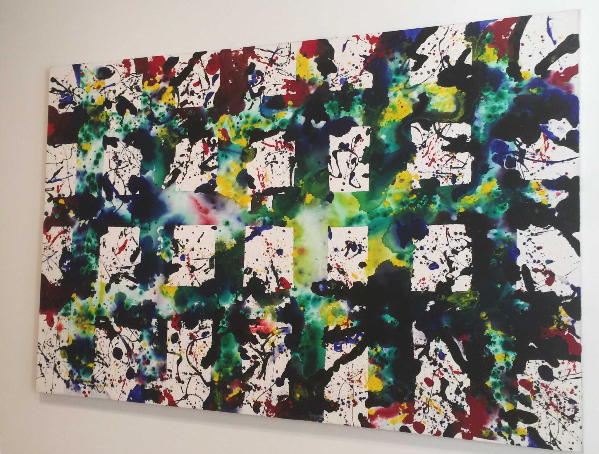 A painting with a white grid of squares and colors exploding from between them