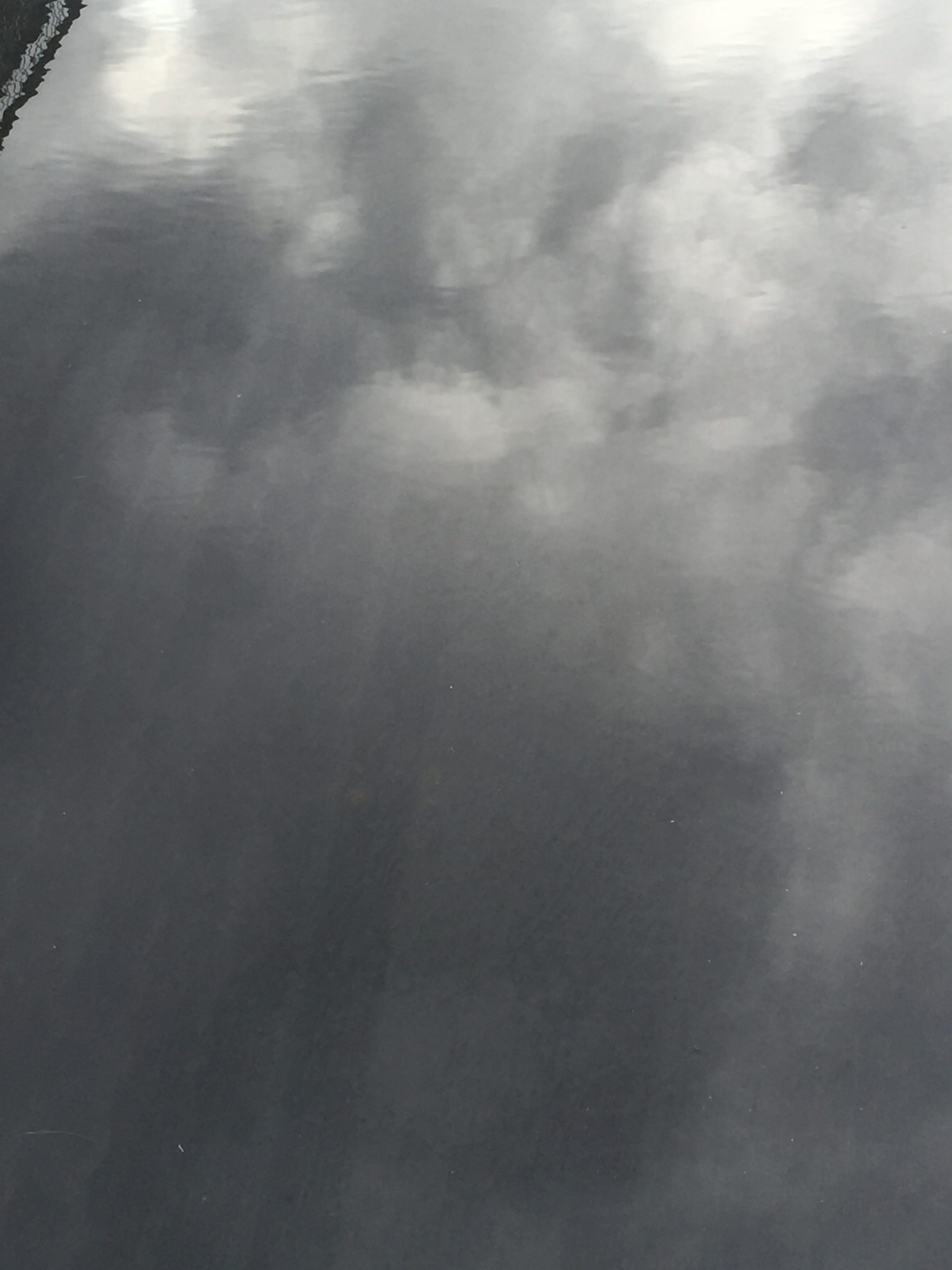 A puddle reflecting clouds in the sky 