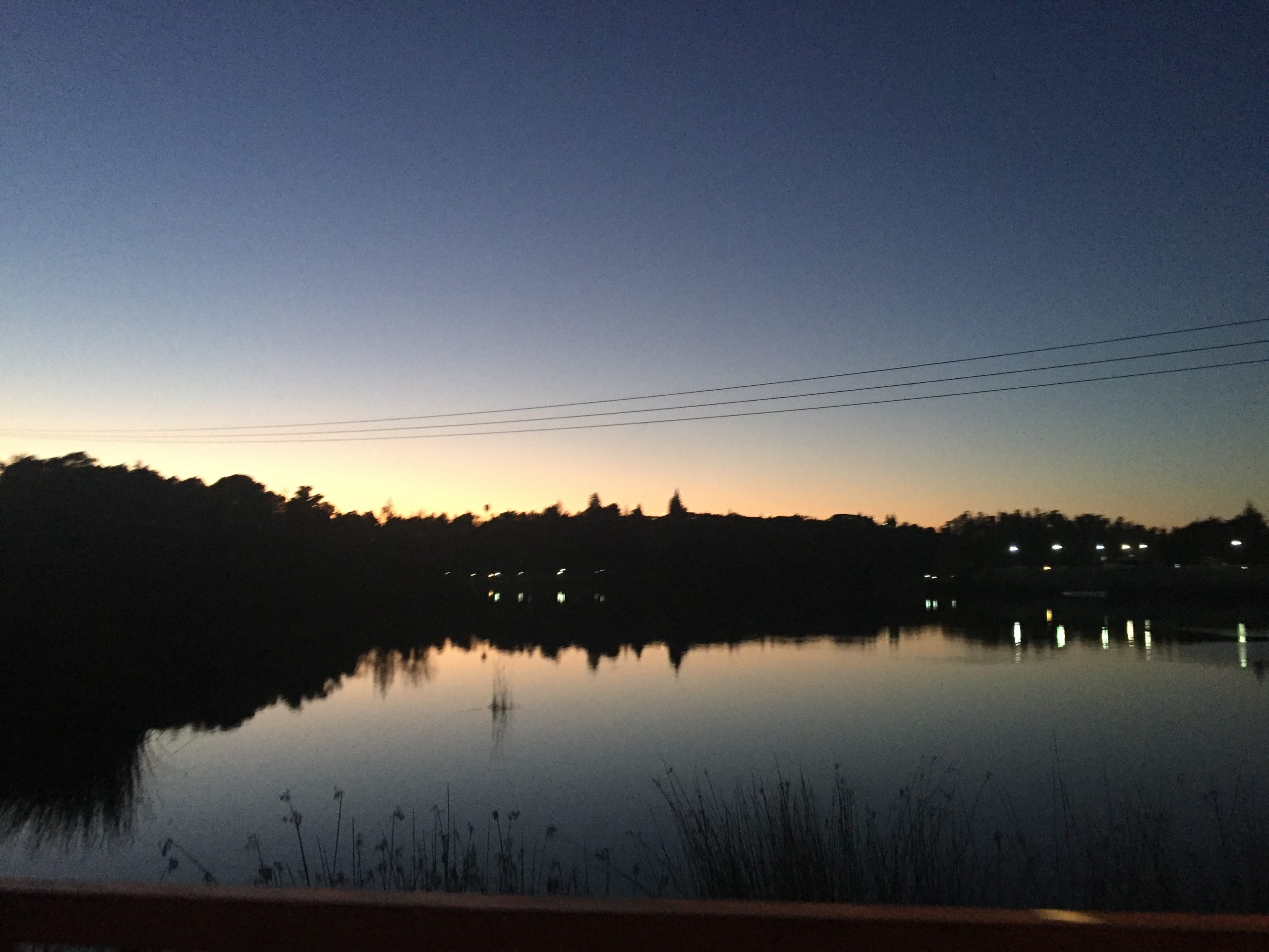 A landscape image of early evening, with a dark horizon, and a gradient of blue and yellow.