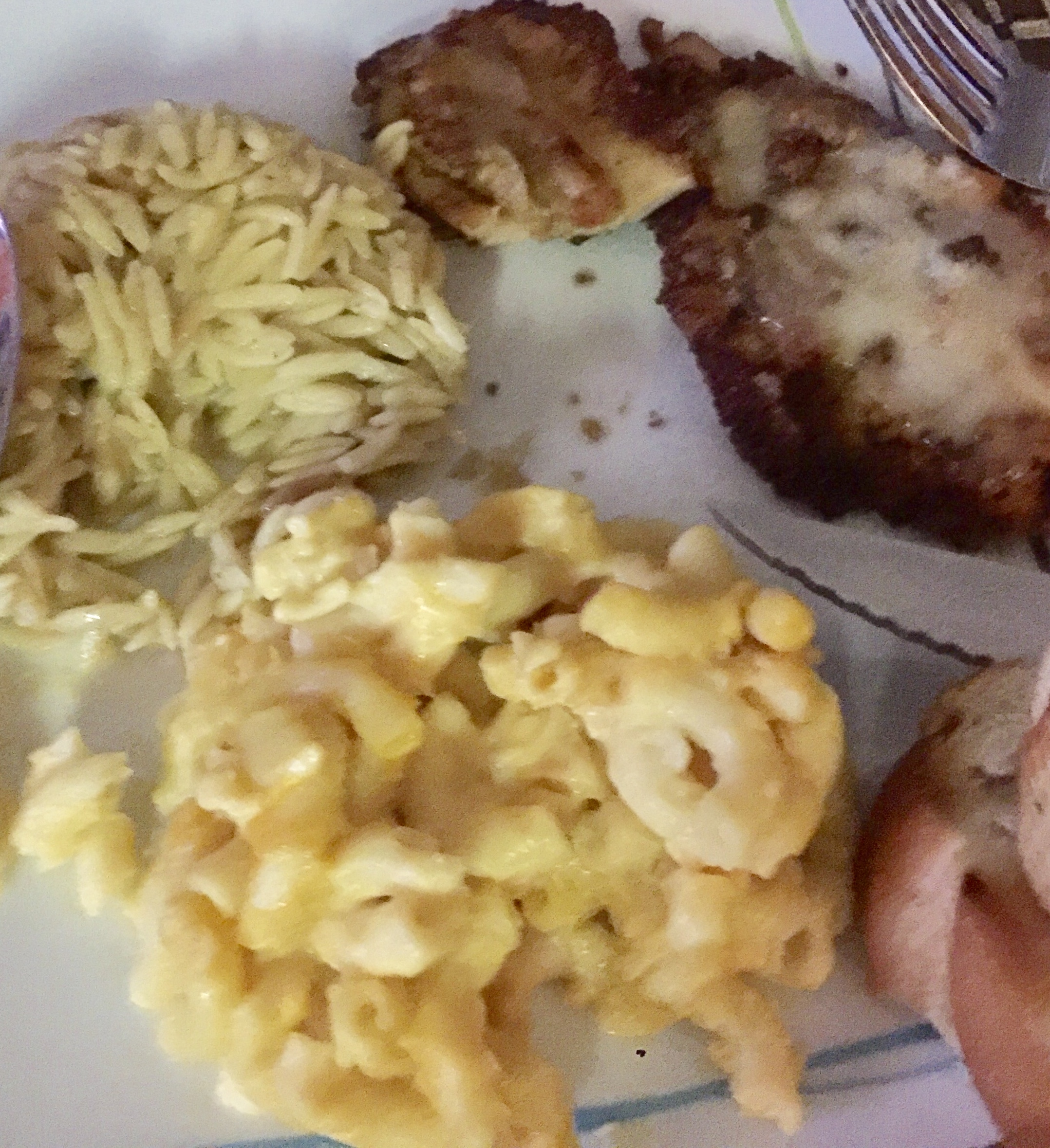 A plate with macaroni and cheese, orso pasta, parmesan chicken, and bread