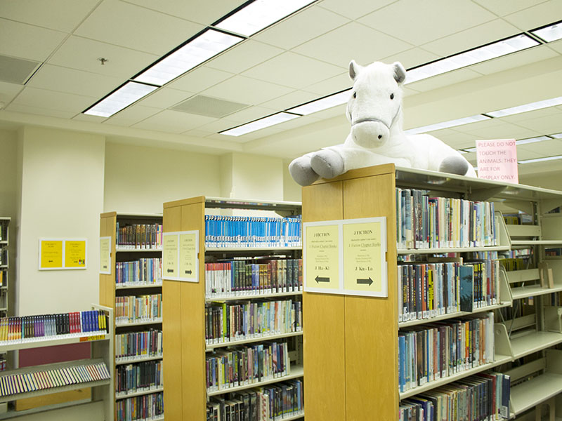 A plush horse on top of stacks in the children's section at the Mountain View Public Library.