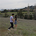 Stefano and Shayda skip in a meadow.