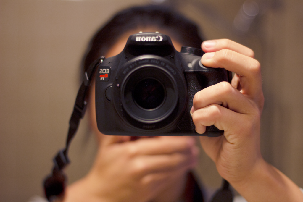 Picture in the mirror, with the camera obscuring the face and a hand over the mouth.