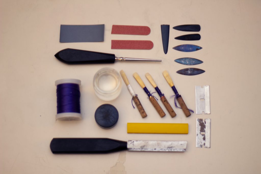 A bunch of tools aligned in a specific way to make a square- ex reeds, razorblades, thread, metal chips, etc.