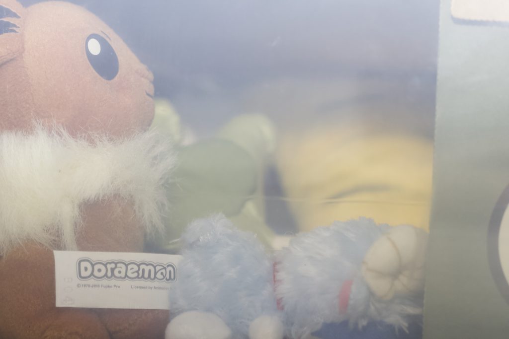 Box with a sort of milky film over the front, showing a bunch of plushies inside.