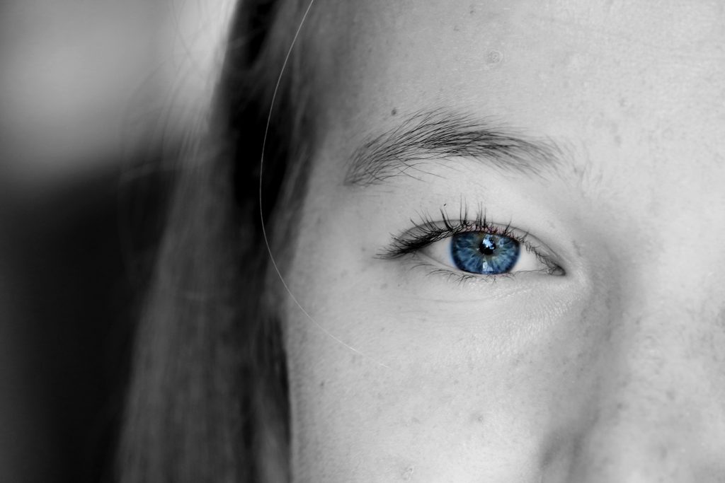 Crystal blue eye stands out in a black and white picture. 