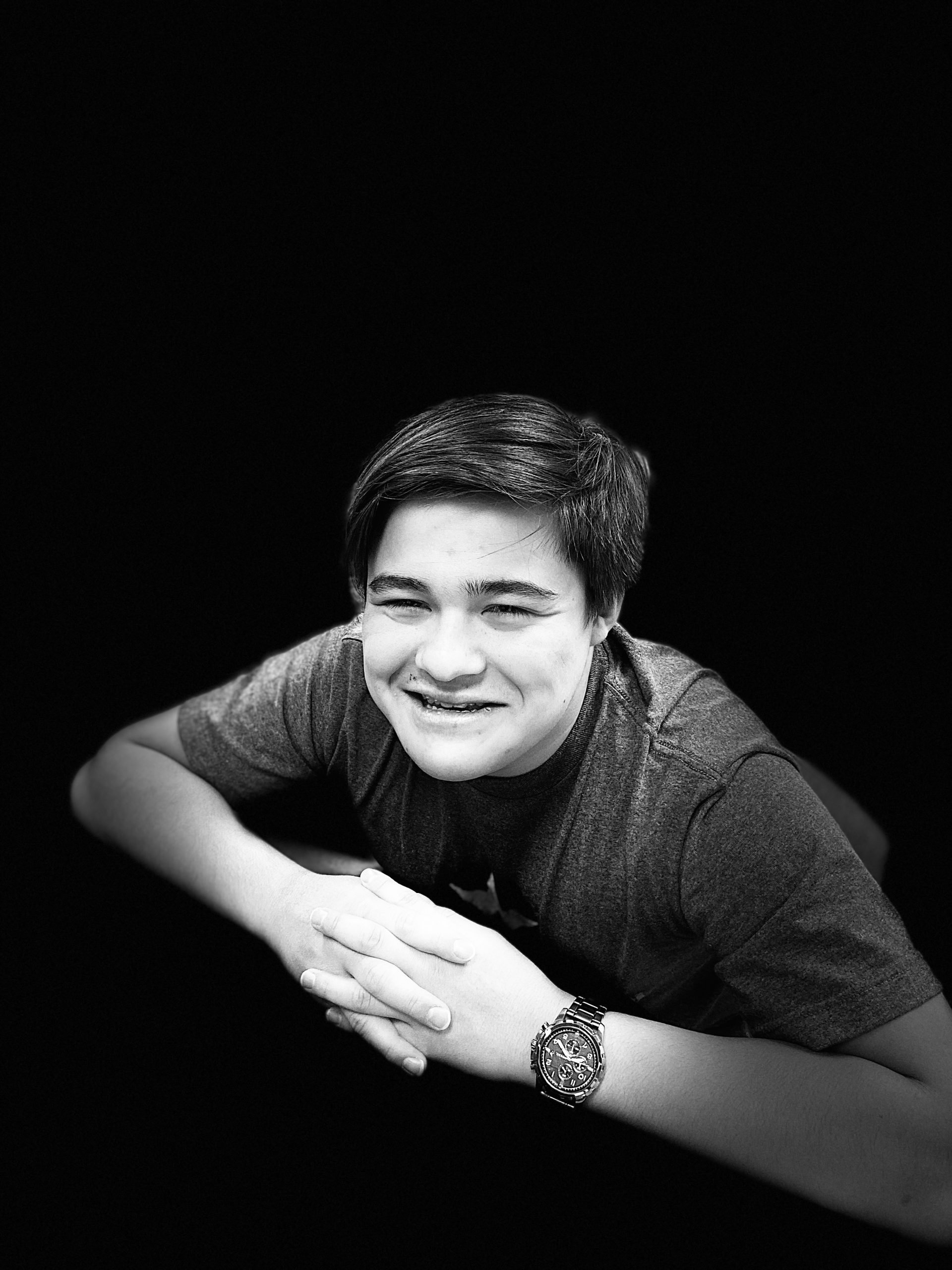 THis is a black and white photo of a man sitting and smiling