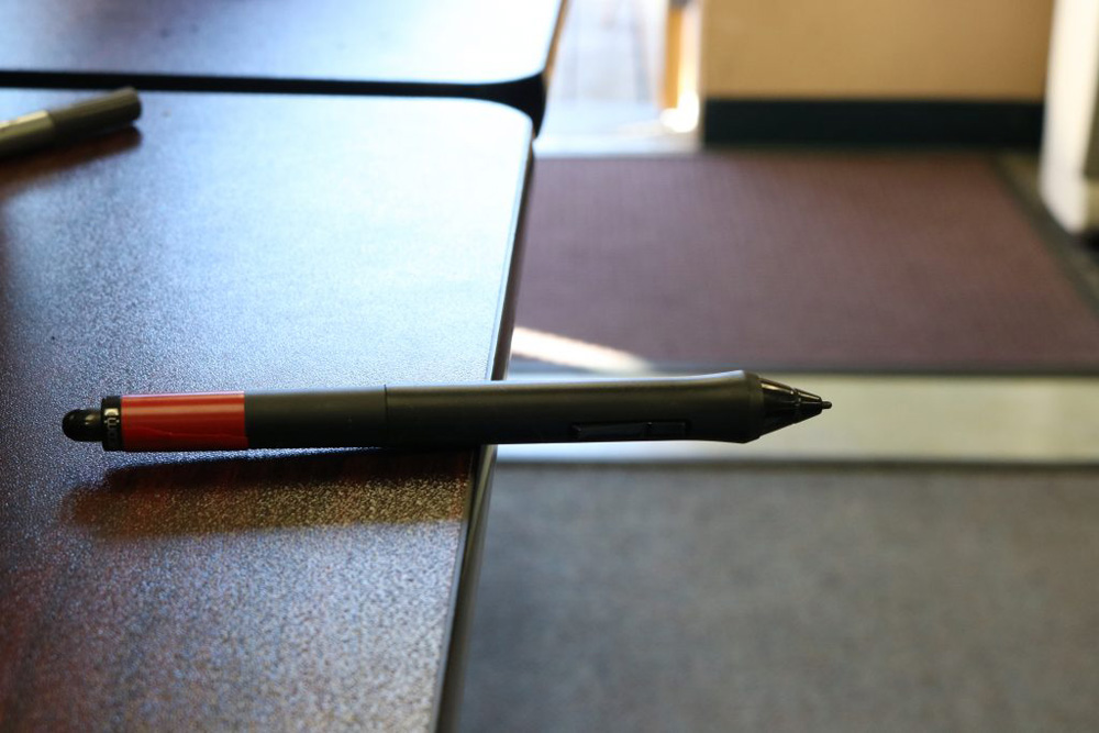 This photo shows a drawing pen balancing on the edge of a desk. Half the pen is over air and the other half is balanced on the desk itself. Showing the meaning of weight or mass.