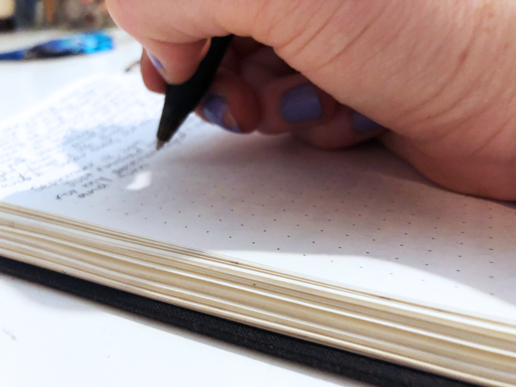 The image shows me writing in my journal.