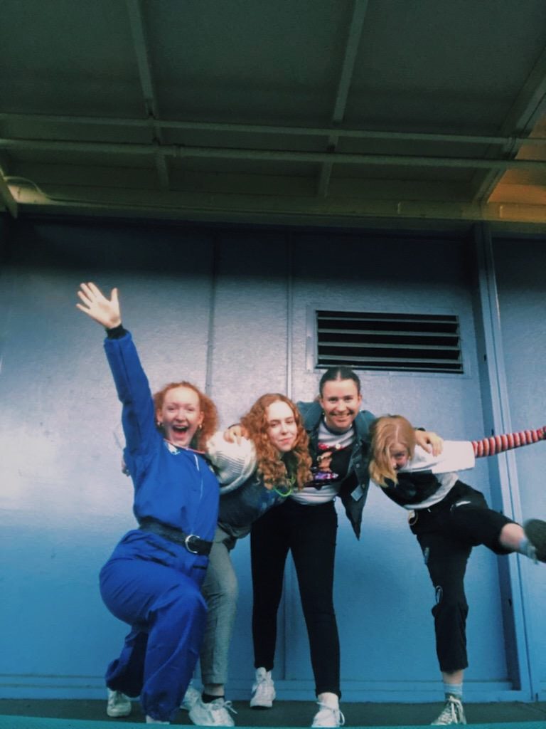 The image shows me and my friends posing for a picture, all smiling and goofing off. 
