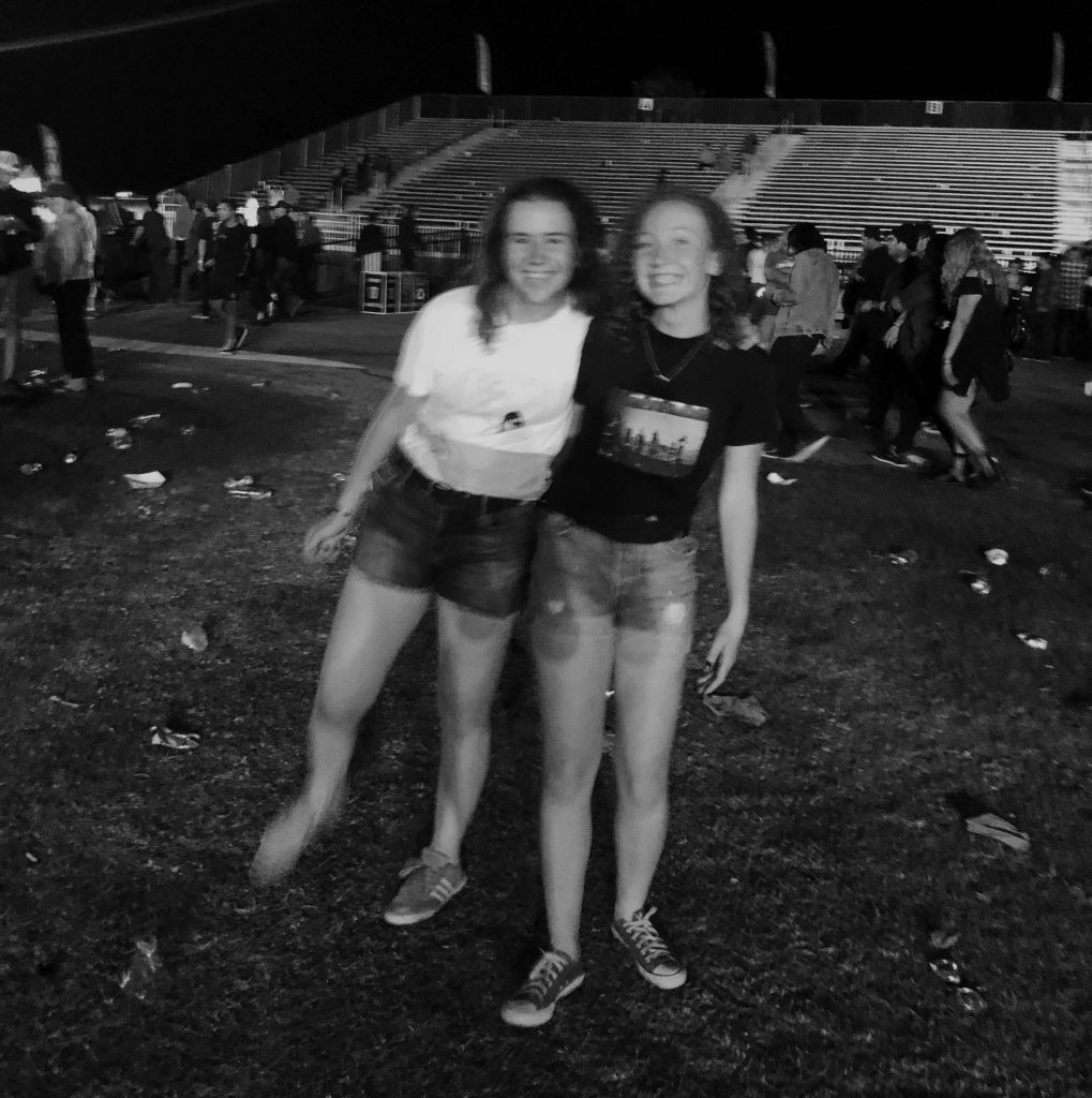 The image shows my friend and I smiling and standing in a crowd of people. 