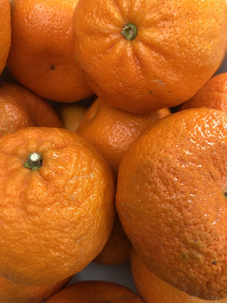 The image shows many tangerines.